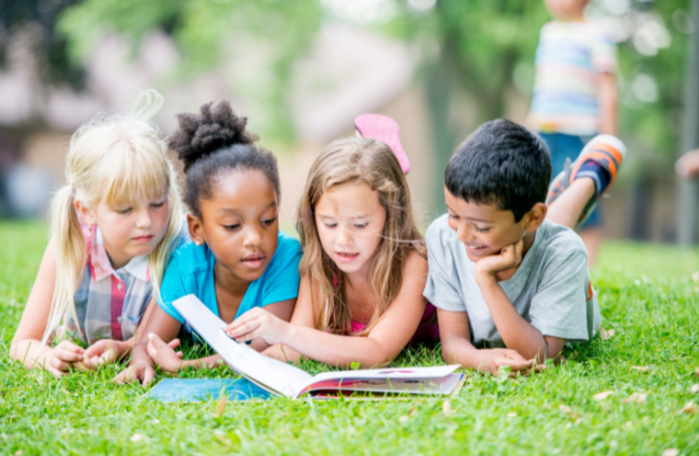 Kids reading on grass