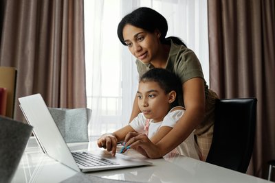 parent and child working on laptop together